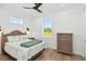 Bright bedroom features hardwood floors, a ceiling fan, and a serene view of the green fields at 2154 Azure Rd, North Port, FL 34286
