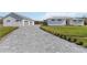 Long driveway leading to home featuring brick pavers, decorative landscape, and attached garage at 2154 Azure Rd, North Port, FL 34286