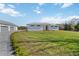 Exterior showcasing a modern home with a well-kept lawn and a detached garage connected by a paved driveway at 2154 Azure Rd, North Port, FL 34286