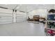 Spacious three car garage with epoxy flooring, storage shelving, and ample lighting at 2154 Azure Rd, North Port, FL 34286