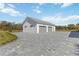 View of the detached three-car garage with a light gray paver driveway at 2154 Azure Rd, North Port, FL 34286