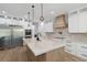 Modern kitchen with custom white cabinets, stone countertops, large island with accent lighting, and stainless steel appliances at 2154 Azure Rd, North Port, FL 34286