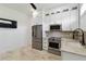 Contemporary kitchenette with stainless steel appliances, white cabinets, and a modern ceiling fan at 2154 Azure Rd, North Port, FL 34286