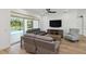 Spacious living room with hardwood floors, ceiling fan, and views of the pool area at 2154 Azure Rd, North Port, FL 34286