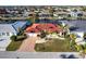 Waterfront home featuring a brick driveway, well-manicured lawn, palm trees, and a vibrant red roof at 2240 Via Esplanade, Punta Gorda, FL 33950