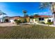 Charming yellow home with a red tile roof, palm trees, and green grass in a waterfront neighborhood at 2240 Via Esplanade, Punta Gorda, FL 33950