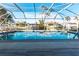 Screened-in pool with clear blue water reflects the sky and surrounding palm trees at 2240 Via Esplanade, Punta Gorda, FL 33950