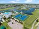 Aerial view of community featuring tennis courts, pool, clubhouse, and beautiful lakefront homes at 24509 Bramhope Ct, Punta Gorda, FL 33980