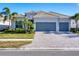 House exterior featuring a three-car garage and manicured landscaping at 25228 Longmeadow Dr, Punta Gorda, FL 33955