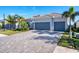House exterior with a three-car garage and paver driveway at 25228 Longmeadow Dr, Punta Gorda, FL 33955