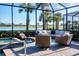 Relaxing lanai with wicker furniture and spa overlooking a lake at 25228 Longmeadow Dr, Punta Gorda, FL 33955