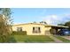 Cute yellow house with a carport and well-manicured lawn at 2544 Elkcam Blvd, Port Charlotte, FL 33952