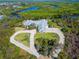 Waterfront property with an aerial view of a sprawling home, circle driveway, and lush surroundings at 27320 Egret Pl, Punta Gorda, FL 33983