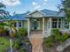 Charming single-story home with lush landscaping, covered porch, and blue front door at 27320 Egret Pl, Punta Gorda, FL 33983