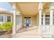 Welcoming covered porch with brick flooring, white columns, and a charming blue front door at 27320 Egret Pl, Punta Gorda, FL 33983