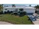 White house with metal roof, landscaping, and two-car garage at 2807 Sancho Panza Ct, Punta Gorda, FL 33950