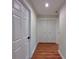 Hallway with wood-look floors, closet, and white paneled doors at 2920 Barry Rd, North Port, FL 34286
