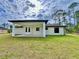 House back exterior with covered patio and grassy yard at 2920 Barry Rd, North Port, FL 34286