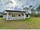 House back exterior with covered patio and grassy yard at 2920 Barry Rd, North Port, FL 34286