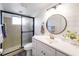 Bathroom with a walk-in shower, white vanity, and stylish fixtures at 325 San Benito Ave, North Port, FL 34287