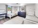 Well-lit bedroom with two twin beds, a dresser, and a workspace at 325 San Benito Ave, North Port, FL 34287