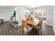 Dining area with a long wooden table, and adjacent living room and kitchen at 325 San Benito Ave, North Port, FL 34287