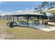 Park picnic area with tables, benches, and grill under a covered pavilion at 325 San Benito Ave, North Port, FL 34287