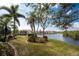 Expansive backyard featuring manicured lawn, tropical landscaping, and serene waterfront views at 3507 Marsala Ct, Punta Gorda, FL 33950