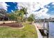 Lush backyard with tropical landscaping leading to a private dock, offering picturesque waterfront living at 3507 Marsala Ct, Punta Gorda, FL 33950