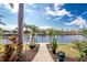 Landscaped backyard featuring stone walkway to private dock, tropical plants, and stunning waterfront views at 3507 Marsala Ct, Punta Gorda, FL 33950