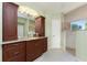 A bathroom features dark wood cabinets, granite counters, decorative wall paper, and a shower at 3507 Marsala Ct, Punta Gorda, FL 33950