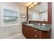 Bathroom with granite counters, dark wood cabinets and a view from the window at 3507 Marsala Ct, Punta Gorda, FL 33950