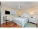 Comfortable bedroom with wood floors, tv, ceiling fan and a window with white shutters at 3507 Marsala Ct, Punta Gorda, FL 33950