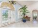 Inviting foyer with double doors, arched windows, and a decorative potted palm at 3507 Marsala Ct, Punta Gorda, FL 33950