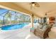Covered patio featuring a pool, spa, and outdoor kitchen overlooking tropical landscape at 3507 Marsala Ct, Punta Gorda, FL 33950