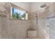 Shower with neutral tile, rock floor and corner seat at 3507 Marsala Ct, Punta Gorda, FL 33950