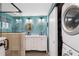 Main bathroom with a large double vanity and stackable washer/dryer at 351 S Mccall Rd, Englewood, FL 34223