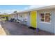 Cute bungalow with a yellow door, patio, and well-maintained landscaping at 351 S Mccall Rd, Englewood, FL 34223