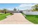 Brick paver driveway leads to a charming light blue home with a white fence at 351 S Mccall Rd, Englewood, FL 34223