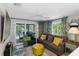Cozy living room with gray sofa, yellow accents, and sliding doors to the pool at 351 S Mccall Rd, Englewood, FL 34223