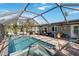 Relaxing pool area with spa, screened enclosure, and patio furniture at 351 S Mccall Rd, Englewood, FL 34223