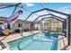 Enclosed pool and spa with patio furniture and screened enclosure at 351 S Mccall Rd, Englewood, FL 34223