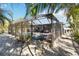 Screened-in pool and spa with patio furniture and tropical plants at 351 S Mccall Rd, Englewood, FL 34223