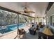 Relaxing screened-in pool area with patio furniture and ceiling fan at 351 S Mccall Rd, Englewood, FL 34223