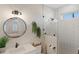 Clean bathroom with white subway tile shower and round mirror at 3800 Carupano Ct, Punta Gorda, FL 33950