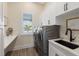 Laundry room with washer, dryer, sink, and built-in shelving at 3800 Carupano Ct, Punta Gorda, FL 33950