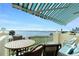 Relaxing balcony with water view, patio furniture, and striped awning at 4410 Warren Ave # 504, Port Charlotte, FL 33953