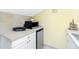 Small kitchen with microwave, mini-fridge, and white cabinets at 4410 Warren Ave # 504, Port Charlotte, FL 33953