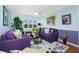 Bright living room with purple couches and floral rug at 4410 Warren Ave # 504, Port Charlotte, FL 33953