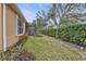 Landscaped backyard with grassy area, hedges, and garden at 4590 Turnberry Cir, North Port, FL 34288